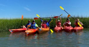 a group of people riding on the back of a boat in the water